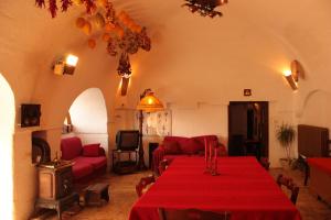 拉泰尔扎Masseria Sierro lo Greco的客厅配有一张桌子和红色桌布