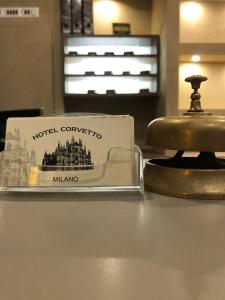 米兰Albergo Corvetto Corso Lodi的酒店广场的标志就在钟旁边