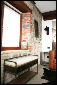 FaedisCasa Vacanze Borc dai Cucs的石墙房间内的一张床位