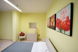 圣塞韦罗City Center n. One的卧室配有一张床,墙上挂有绘画作品