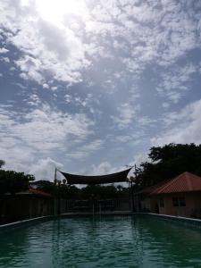 DomburgSurinat Luxury Resort的一个有阴天背景的大型游泳池