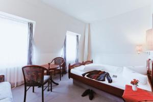 德累斯顿基平酒店的卧室配有一张床和一张桌子及椅子