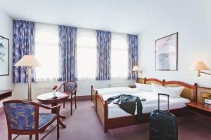 德累斯顿基平酒店的酒店客房带一张床、一张桌子和椅子
