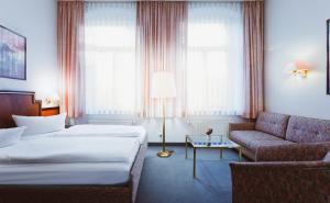 德累斯顿基平酒店的酒店客房,设有两张床和一张沙发