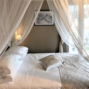 Castel BaroniaB&B Baronia Luxury Rooms的一间卧室配有一张带白色床单的床和一扇窗户。