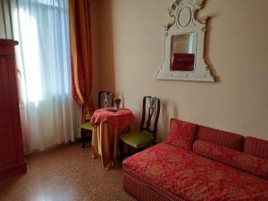 威尼斯Alloggi Acquavita - checkin at "Alloggi SS Giovanni e Paolo"的客厅配有红色的沙发和桌子