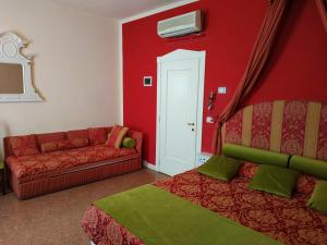威尼斯Alloggi Acquavita - checkin at "Alloggi SS Giovanni e Paolo"的红色的房间,配有沙发和一张床