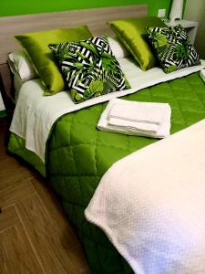 卡塔尼亚Holiday In Home | Le Ciminiere的一张配有绿色和白色床单及枕头的大床