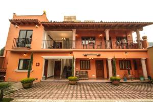 迪坡斯特兰Posada Hacienda Real的一座大型橙色房屋,设有庭院和阳台