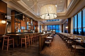 明尼阿波利斯明尼阿波利斯凯悦酒店的餐厅设有配备了桌椅的长酒吧