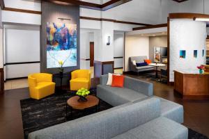 达拉斯达拉斯中央公园广场凯悦酒店的客厅配有蓝色的沙发和黄色的椅子