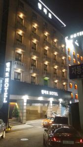 光明市Rampart Hotel的一家晚上停在酒店前面的汽车酒店