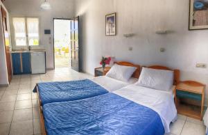 伊奥斯乔拉海伦娜旅馆的一间卧室配有一张带蓝白色床单的大床