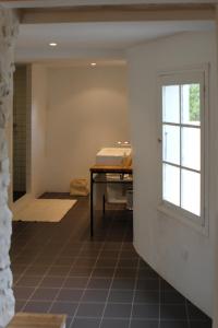 巴尔日蒙Beautiful townhouse in Bargemon的浴室设有桌子和窗户,铺有瓷砖地板。