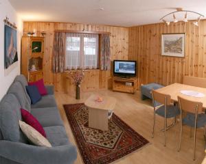 采尔马特美迪木木屋酒店的客厅配有蓝色的沙发和电视