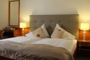 沃尔特湖畔韦尔登鲍尔特斯酒店的卧室配有一张带白色床单和枕头的大床。