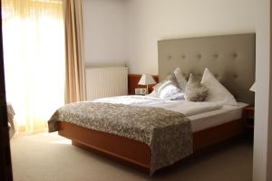 沃尔特湖畔韦尔登鲍尔特斯酒店的卧室配有一张带白色床单和枕头的大床。