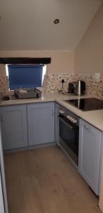 MeersigFlamingo Cottage no 12的厨房配有白色橱柜和炉灶烤箱。