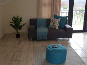 希尔顿The Living Collective - The Gates的带沙发和蓝色搁脚凳的客厅