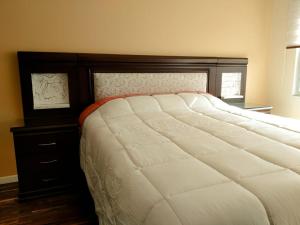 拉巴斯Meraki的一间卧室配有一张大床和木制床头板