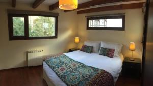 圣马丁德洛斯Abedul Apartamentos的卧室配有一张白色大床和两个窗户