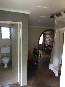 ShanjunguMusungwa Safari Lodge的客房设有带卫生间的卧室和开放式门。