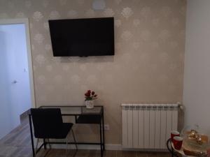 米耶雷斯H.Albar Mieres的一间房间,配有一张桌子和一台墙上的电视