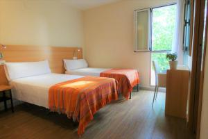 QuesaHotel de Montaña La Rocha的酒店客房设有两张床和窗户。