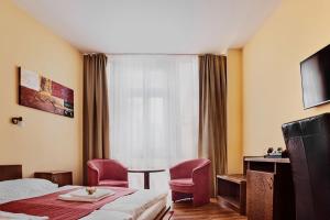 科马尔诺班德里姆酒店的酒店客房设有一张床、两把椅子和一扇窗户。