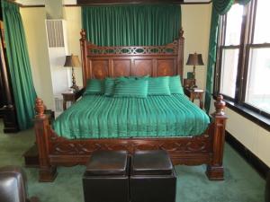 芝加哥美国桥港马球住宿加早餐旅馆的一间卧室配有一张带绿色床单的大型木制床。