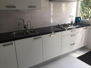 阿尔克马尔Cozy room in residential Alkmaar的厨房配有白色橱柜和水槽