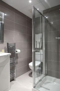 伦敦肯辛顿花园酒店的一间带玻璃淋浴和卫生间的浴室
