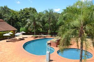 伊瓜苏港伊瓜苏马可波罗套房酒店的棕榈树度假村内的游泳池
