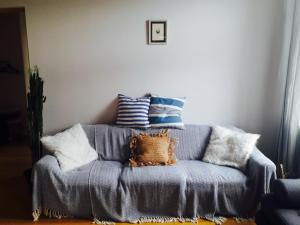 库雷萨雷Stylish apartment with sauna的一张蓝色沙发上摆着一大堆枕头