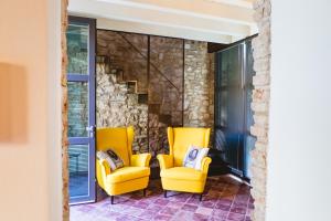 代森扎诺-德尔加达Villa Colli Storici的两张黄色椅子和一个楼梯
