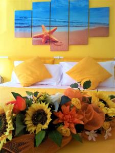卡莫利斯特拉海滨酒店的一间卧室,床上摆放着太阳花