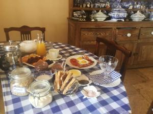 斯泰伦博斯Gemoedsrus Farm的一张桌子,上面有早餐食品,放在蓝白格子桌布上
