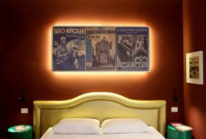 维罗纳OFFICINA TESINI Guest Rooms Verona的卧室配有一张床铺,墙上挂着两张海报