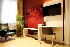 维罗纳OFFICINA TESINI Guest Rooms Verona的客厅配有两把椅子和电视