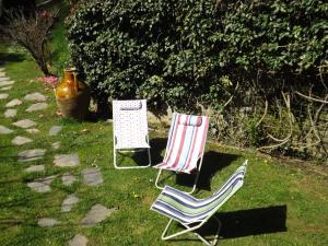 比耶拉Guest house Cascina Belsito的两把椅子坐在院子里的草地上