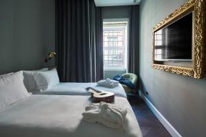 里斯本O Artista Suites by Europe的酒店客房,设有两张床和镜子