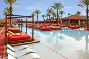 查尔斯湖查尔斯湖金块酒店的一个带椅子和棕榈树的大型游泳池