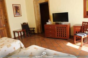 克雷塔罗圣地亚哥金塔酒店的客厅配有平面电视和1张床。