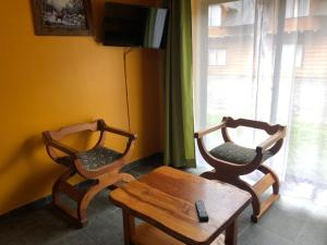 普孔阿尔卑斯酒店的配有电视的客房内的2把椅子和1张桌子