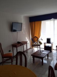 安托法加斯塔Apart Antofagasta的客厅配有电视和桌椅
