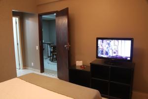 巴雷图斯Hotel Kehdi Plaza的一间卧室配有一张床,梳妆台上配有电视