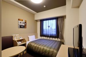 IshiokaHotel Route-Inn Ishioka的酒店客房设有床和窗户。