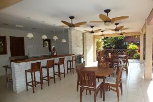 伊利亚贝拉Residencial Yacamim B39的餐厅设有酒吧,配有木桌和椅子