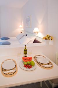 林都斯威乐迪林德斯酒店的一张桌子,上面放着一瓶葡萄酒和一盘水果