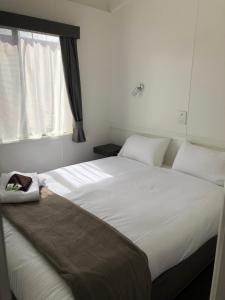 Mount Duneed吉朗冲浪海岸高速公路假日公园的卧室配有一张大白色床和窗户